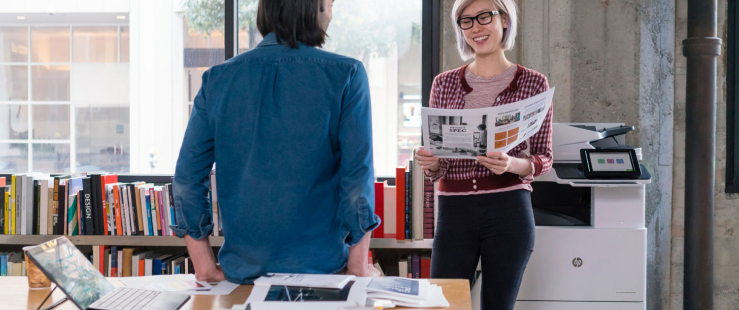 Two Coworkers Are Jolly Standing Next To Hp Printer In Office