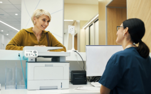 Woman Smiling And Talking To Young Adult Woman Receptionist