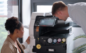 Businessman And Woman Using Photocopying Paperwork In Office