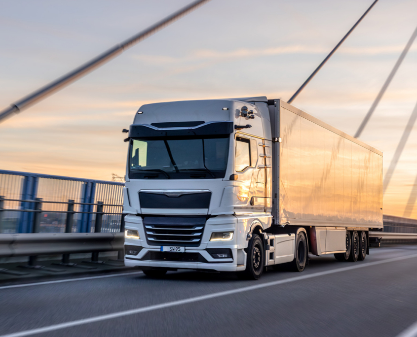 White Truck Crossing Bridge At Sunset. Urban Logistics In Motion