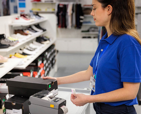 Woman using a Zebra label printer in a retail store