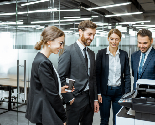 Group Of Business People Hanging Out Together Near The Copier