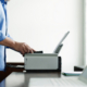 Side View Midsection Of A Mature Man Using Printer At Study Table In House